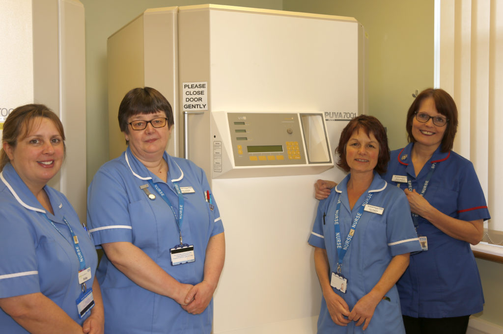 The Phototherapy Team standing beside equipment.