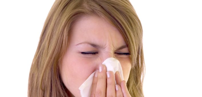 Generic photograph of a woman blowing her nose into a tissue or handkerchief