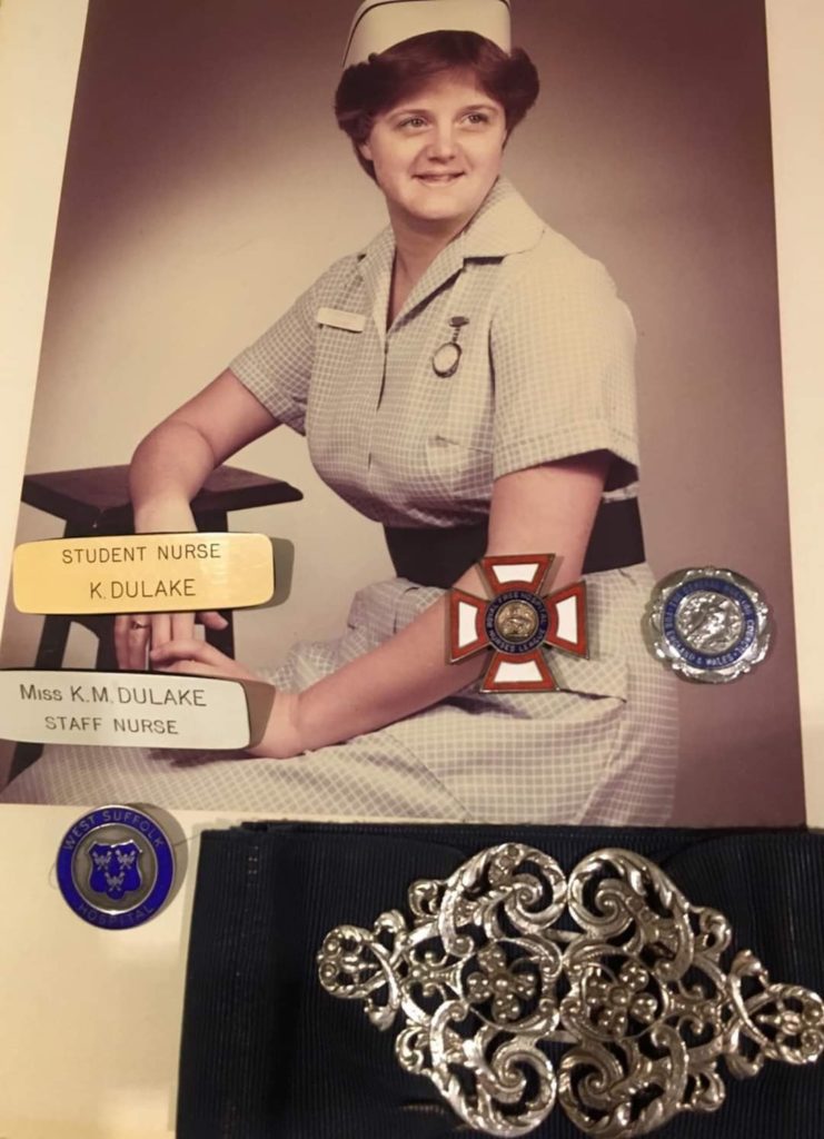 Photograph of Karen Moss with her name badges and nurse's buckle 
