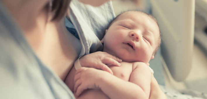 Generic photograph of a baby asleep in its mother's arms