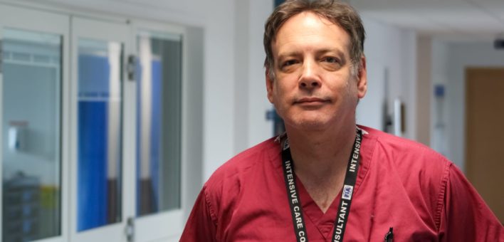 Photograph of Dr Paul Carroll in scrubs, no mask