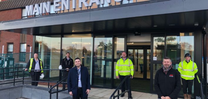 Colleagues from ESNEFT’s Estates and Facilities team and representatives from building firms involved in the project stand outside the new main entrance at the south end of Ipswich Hospital.