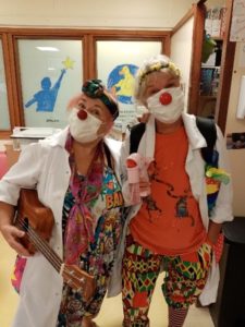 A picture of Dr Fidget and Dr Mischief, two clowns with red noses wearing white doctors coats over their colourful clown costumes.