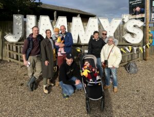 A group of Welly Walkers stand in front of the Jimmy's sign