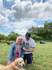 Woman with pink wig and man in field