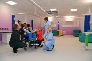A group of healthcare staff and a young patient in a new ward