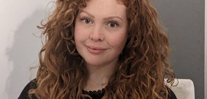 Woman looking at camera with red curly hair