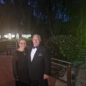 Man and woman dressed up for formal occasion standing outside