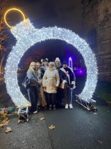 Group of people standing under large Christmas bauble