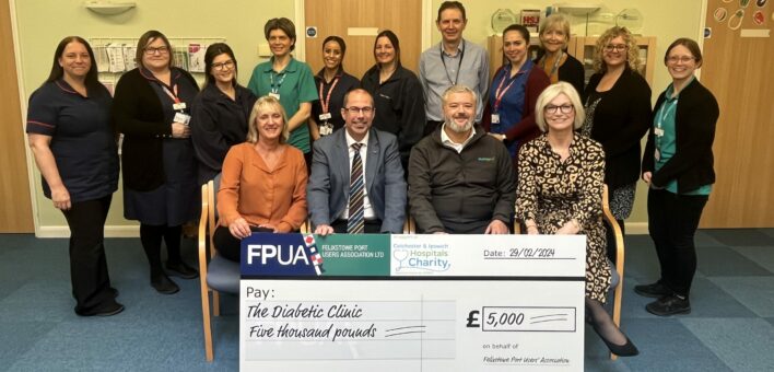 A group of people present a large charity cheque to hospital staff