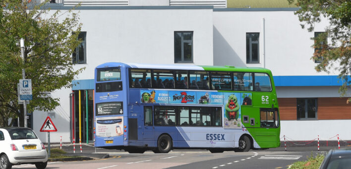 A double decker bus turns in the road outside Colchester Hospital