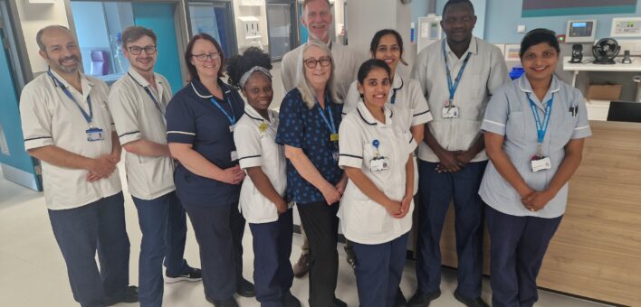 A group of NHS staff stand together on a ward