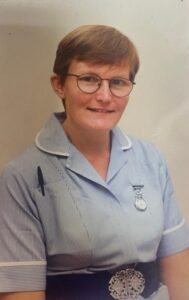 A woman in nurses uniform smiling
