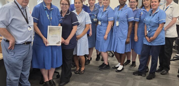 Anna celebrates her award stood with ESNEFT interim chief executive Adrian Marr, lead community nurse Laura Ward, and members of the community team.